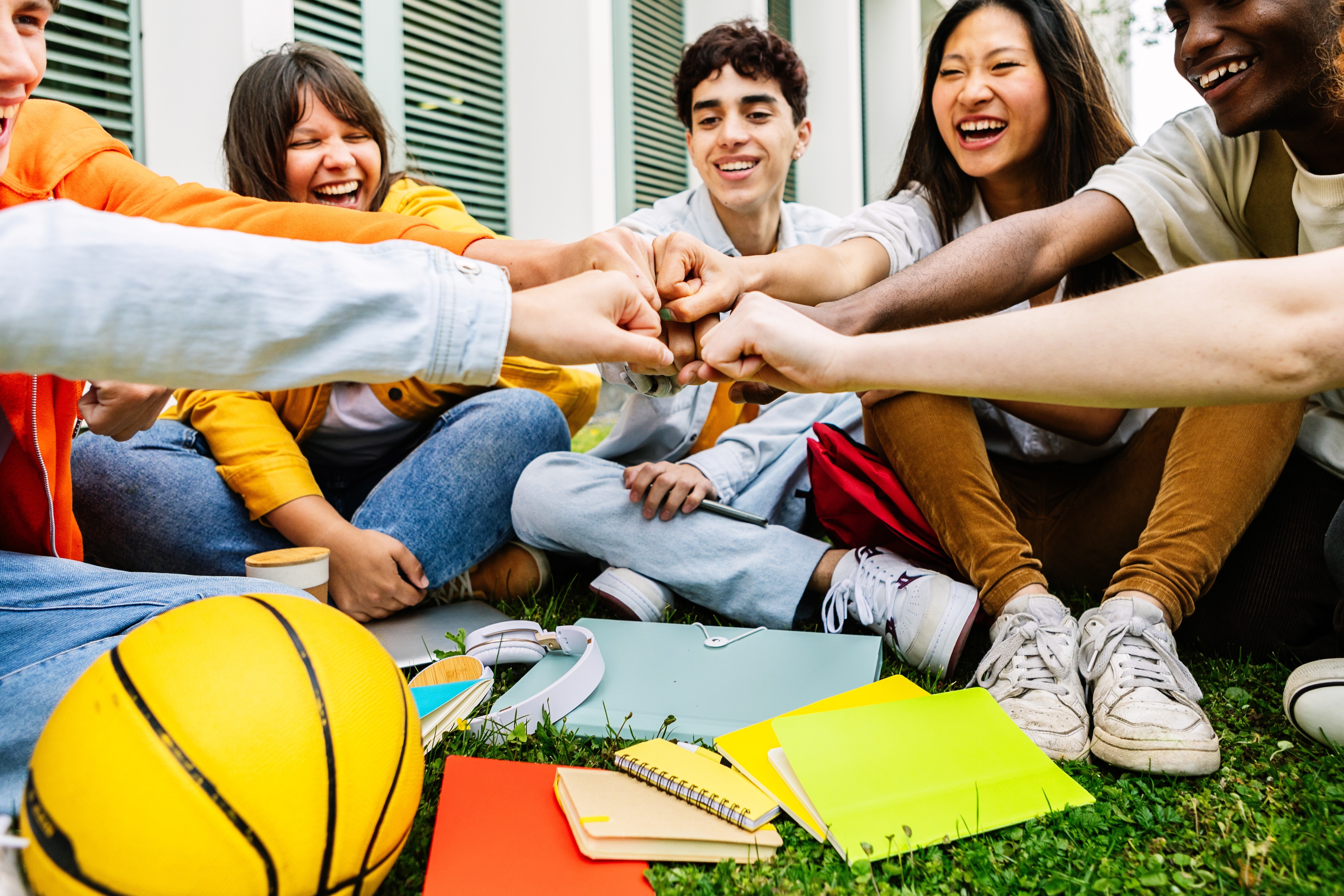 Group of college students joining hands showing support and cooperation